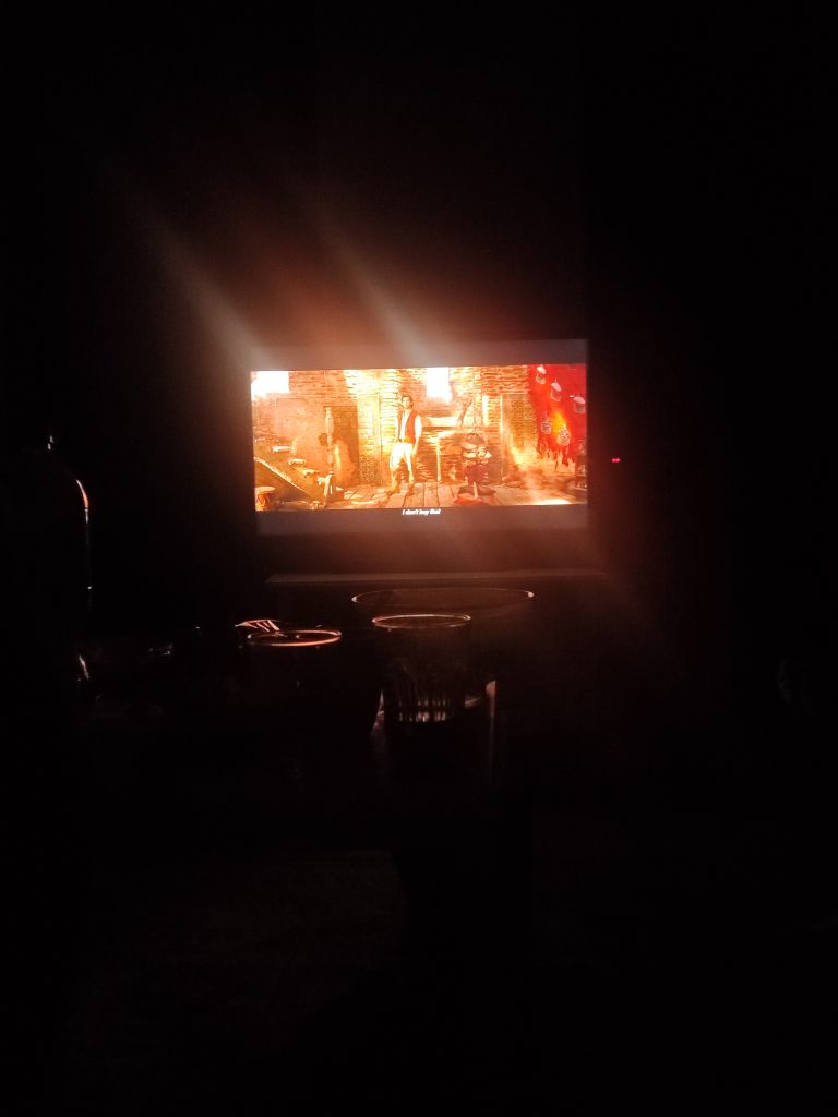 Kuvassa suuri näyttö pimeässä huoneessa, näytöllä video menossa.