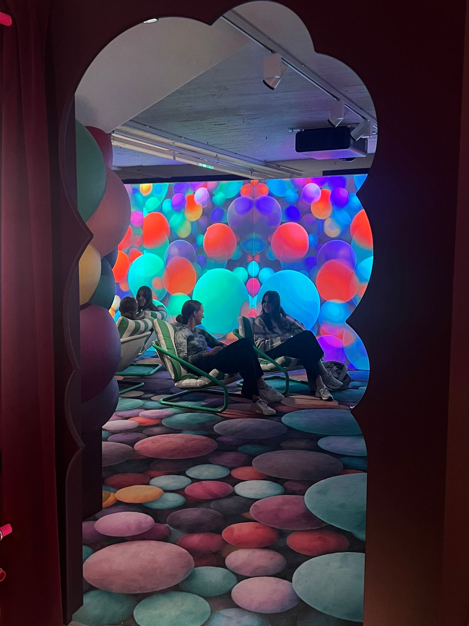 Kaksi ihmistä istumassa pallopintaisessa huoneessa nojatuoleissa.