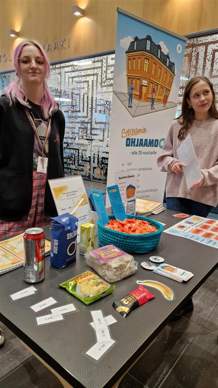 Opiskelijaharjoittelijat Aada ja Annika pitämässä ruokien hinnoittelu-pistettä Pidä kämppäs-kiertueella.