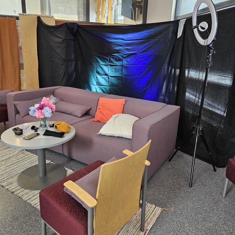 Nuorisopalveluiden 80 tunnin striimin haastattelunurkkaus, missä sohva, tuoli ,pöytä ja valoja.