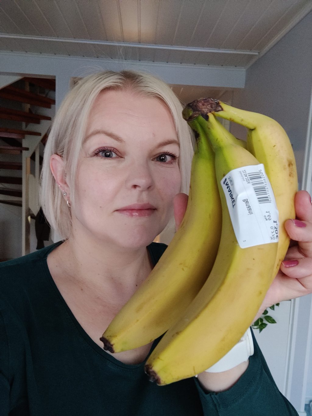 Nainen kädessään banaaneja.