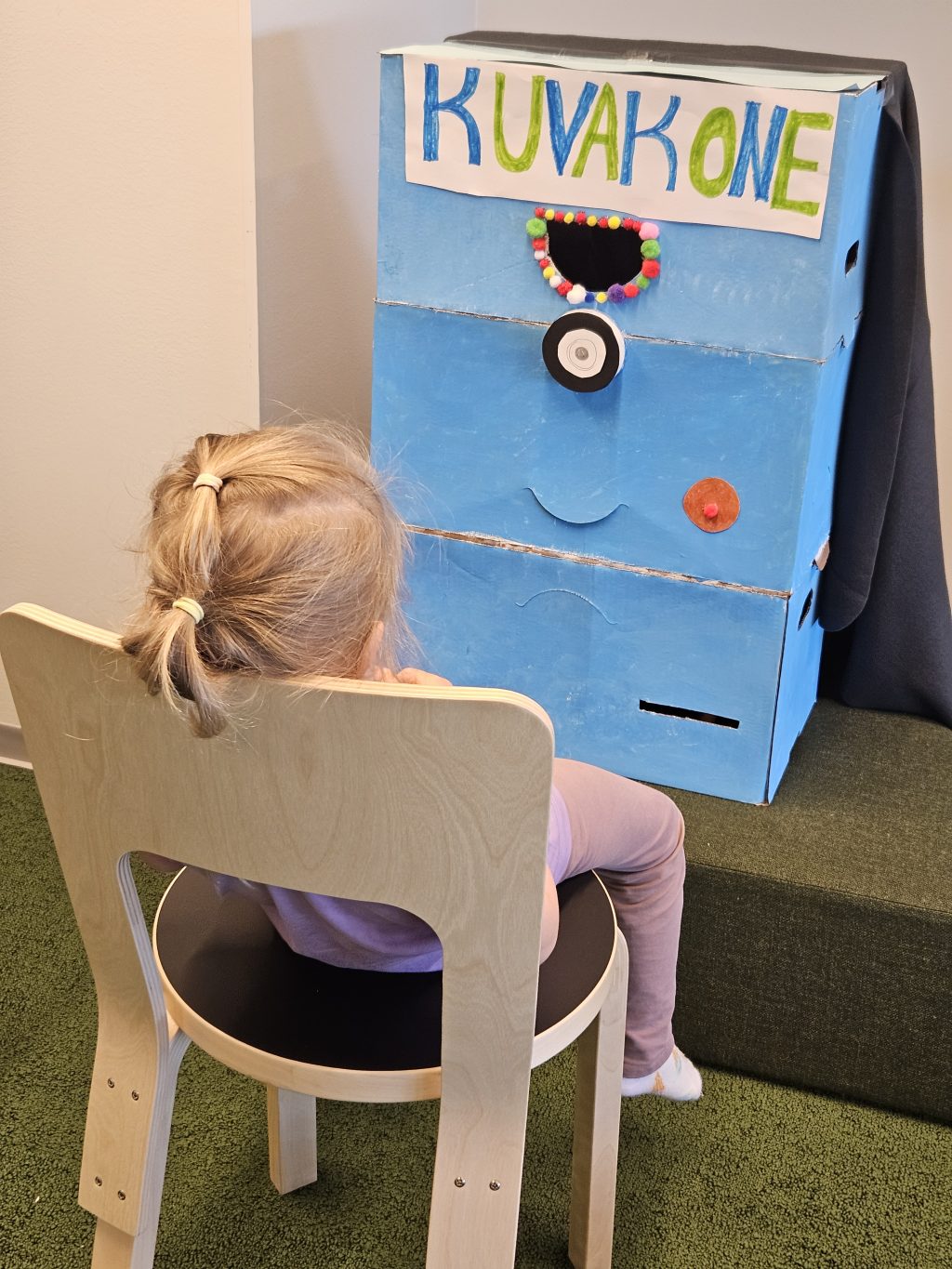 Lapsiasiakas kuvakoneen edessä.