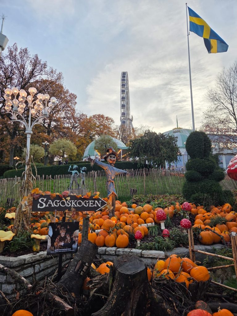 Kukkapenkki, jossa Halloween-kurpitsoja, taustalla Ruotsin lippu ja maailmanpyörä