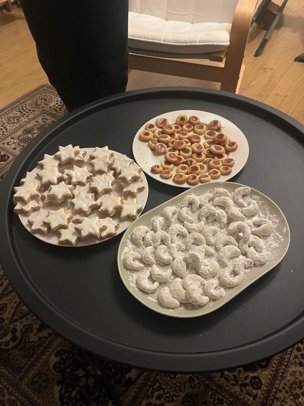 Tähdenmuotoisia, pyöreitä ja kuunmuutoisia pikkuleipiä tarjoiluvadeilla